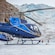 Two helicopters are parked on the glacier, while people gather near a large domed tent